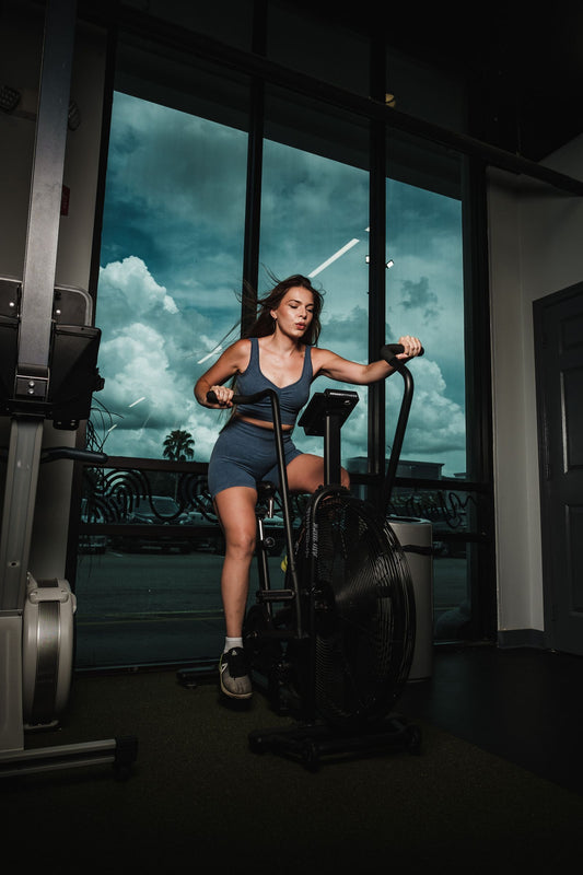 Woman training on a stationary exercise bike indoors, illustrating the best exercise bikes available in South Africa