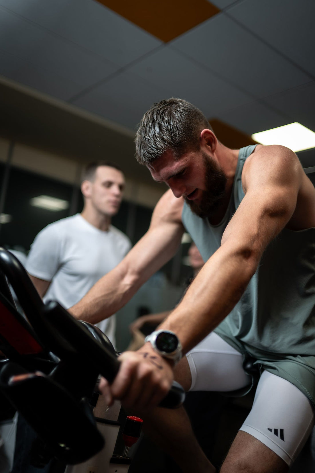 Athletes in a high-intensity indoor cycling session, illustrating air bike training for HIIT and CrossFit in South Africa