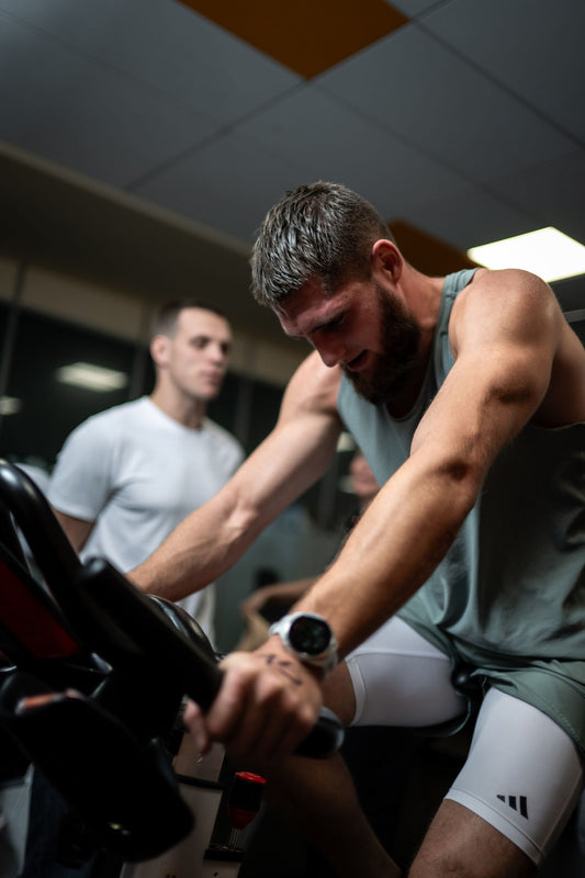 Athletes in a high-intensity indoor cycling session, illustrating air bike training for HIIT and CrossFit in South Africa