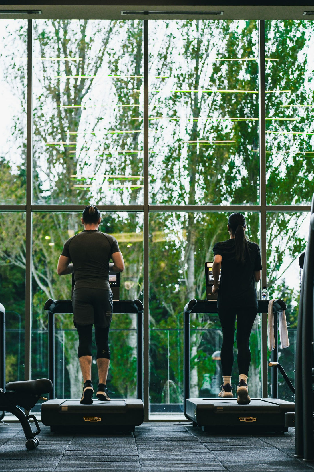 Two athletes running hard on gym treadmills, illustrating curved treadmill HIIT and sprint training in South Africa
