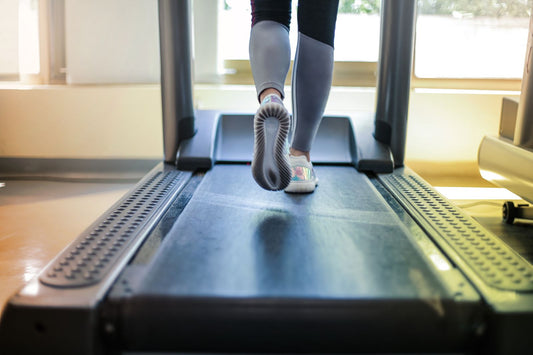 Person using a quiet folding treadmill in an apartment, showing a compact home cardio setup