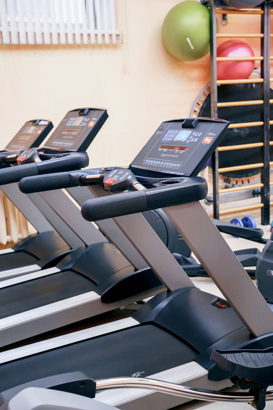Row of commercial treadmills with consoles in a modern gym, illustrating commercial treadmill options in South Africa