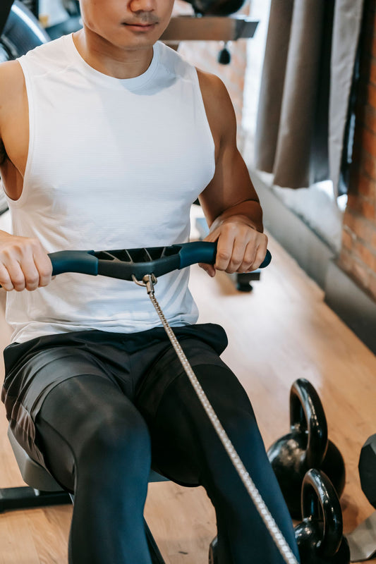 Man training on a rowing machine in a gym, comparing water, air and magnetic rowing machine resistance in South Africa